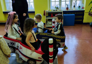 Dzieci prowadzą piankowy pojazd.