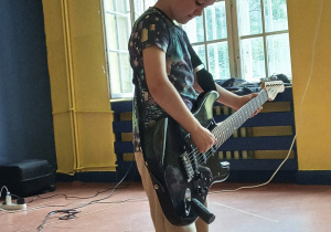 Jan z grupy "Stokrotki" gra na gitarze